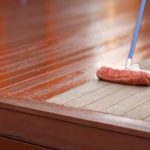 Worker deck staining a home deck