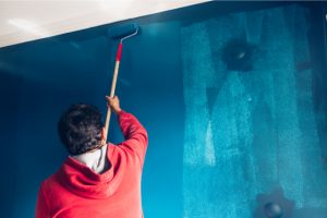 Painter Painting Wall blue with a roller